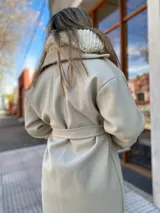 Tapado color beige con cuello solapa, corte recto y cinturón de lazo.