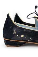 Zapato tipo blucher de pelo de pony en color negro con salpicaduras doradas. Presenta cierre de cordones, ribetes dorados a contraste y una silueta geométrica con aberturas laterales. Cuenta con un tacón bajo forrado en el mismo material.