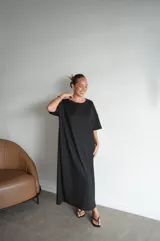 Vestido largo negro de viscosa, con cuello redondo, mangas cortas y corte holgado.