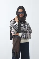 Sweater de punto con diseño jacquard de inspiración nórdica, cuello redondo y mangas largas. Presenta un patrón geométrico en tonos tierra, azul y blanco, con puños y ruedo acanalados.
