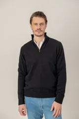 Sweater de punto color negro, con cuello alto y cierre frontal parcial, de manga larga con puños y ruedo acanalados.
