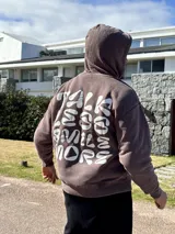 Canguro marrón con capucha y estampado blanco en la espalda con la frase "Talk Less Smile More".