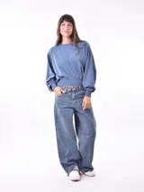 Buzo de tejido de punto color azul piedra, con cuello redondo y costuras verticales en el frente. Presenta un calce holgado con mangas amplias y puños y cintura ajustados con elástico.