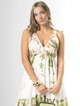Vestido largo confeccionado en mezcla de tencel y lino, con fondo off white y estampado floral en tonos rosados, rojos y verdes. Cuenta con escote en V pronunciado, breteles anchos ajustables con lazos en los hombros, corte bajo el busto y falda amplia con volados escalonados.