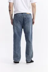 Jean baggy de hombre, color azul claro, con tiro medio, corte amplio en piernas y cadera, y pasacinto.