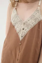 Vestido midi lencero marrón de lino, con escote en V pronunciado con aplique de encaje en contraste, breteles regulables y botonadura frontal decorativa.