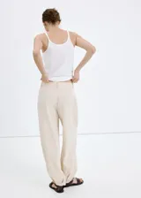 Pantalón de corte recto y tiro regular, con diseño ligero de pinzas en la cintura y bolsillos laterales.
