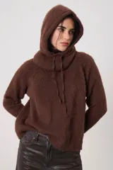 Polera de tejido suave con textura, cuello alto, mangas largas y silueta recta.