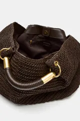 Maxi bolso color marrón con efecto rafia, doble asa de mano rígida con detalles metálicos dorados y cierre con botón imantado.