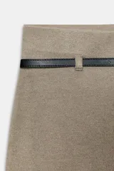 Pantalón palazzo de tiro alto color beige, con pierna ancha y cinturón fino de efecto piel negro con hebilla metálica.