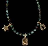 Collar de cuentas de piedra crisocola en tonos turquesa y verde, con dijes colgantes de bronce que incluyen una estrella, una medalla rectangular con estrella en relieve y una herradura.