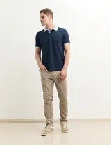 Pantalon de corte recto y estilo casual, confeccionado en tela de gabardina color kaki, con bolsillos laterales y traseros.