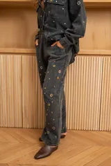 Pantalón azul de corte recto y fluido, con ojales metálicos integrales.