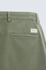 Pantalón chino de corte ajustado, color beige, con bolsillos laterales y bolsillos traseros de vivo. Cuenta con cierre frontal de cremallera y botón.