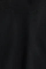 Top de punto fino negro, de manga corta y cuello alto acanalado. Presenta puños y bajo en punto acanalado.