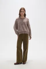 Sweater de punto a rayas horizontales en tonos marrón y blanco, con cuello redondo y cierre frontal parcial con botones. Presenta un diseño holgado de manga larga con puños y ruedo acanalados.