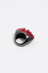 Anillo con forma de labios rojos con cristales incrustados y base negra.