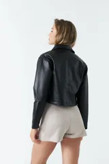 Sobrecamisa de eco cuero con corte cropped, silueta recta y bolsillos frontales con tapa. Presenta cierre frontal con botones y acabado soft.