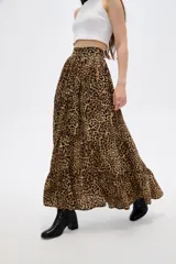 Falda larga de poliéster con estampado animal print de leopardo, diseño de corte amplio con volados en el ruedo y cierre frontal con botones.