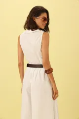 Camisa blanca sin mangas con cuello solapa y cierre frontal con botones.