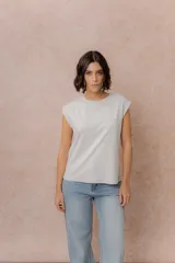 Remera de algodón color gris claro, con cuello redondo y mangas con vuelta que le otorgan estructura. Presenta un corte relajado y diseño minimalista.