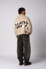 Campera tejida de punto con cierre frontal completo, cuello tipo polo y diseño con franja horizontal en contraste con estampado gráfico. Presenta puños y ruedo acanalados, con corte holgado.