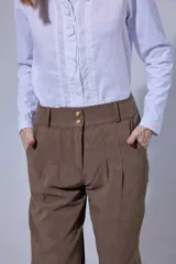 Pantalón tipo bombachita con pinzas que aportan volumen, confeccionado en Tencel. Presenta cierre frontal con botones dorados, bolsillos delanteros y ruedo ajustable mediante botón dorado.