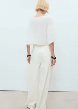 Jersey blanco de punto fino con cuello barco, manga acampanada y diseño oversize.