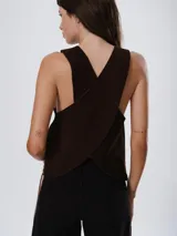 Chaleco de cuero marrón con diseño cruzado en la espalda y ajuste lateral mediante cordones. Presenta un corte holgado y moderno, ideal para usar como prenda de superposición.