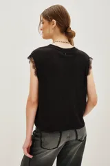 Musculosa blanca de lino con cuello redondo y detalle de encaje en las mangas.