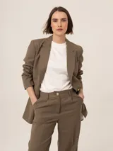 Blazer marrón con estampado a cuadros, solapas de muesca, cierre frontal con botón y bolsillos delanteros.