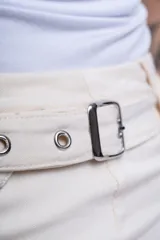 Minifalda negra con tres hileras de correas ajustables con hebillas plateadas.