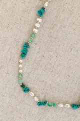 Collar de diseño artesanal que combina piedras naturales en tonos verdes y turquesas con perlas irregulares y pequeñas cuentas doradas.