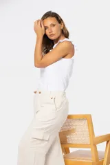 Pantalón cargo de lino color beige, de corte ancho y silueta relajada, con bolsillos laterales tipo cargo y cintura con trabillas.