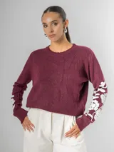 Sweater de tejido de punto color borgoña con escote en V y bordado de flores blancas en las mangas.