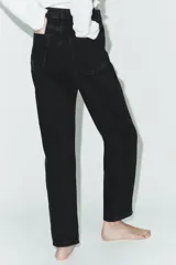 Jeans de tiro alto con corte mom fit, cinco bolsillos y cierre frontal con cremallera y botón metálico.