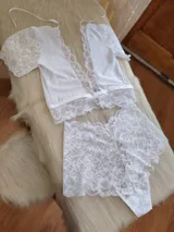 Conjunto de lencería compuesto por un top de encaje con mangas cortas y escote profundo, y una bombacha tipo hipster de encaje completo.