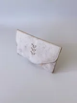 Billetera de cuero color crudo con textura, cierre con broche y monedero externo.