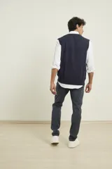 Chaleco de punto negro con cuello en V y ribete en el bajo.