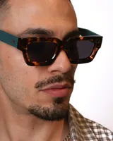 Lentes de sol rectangulares con montura gruesa color carey.