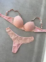Conjunto de lencería compuesto por un corpiño taza soft con detalles de puntilla y una bombacha tipo less a juego con paneles de encaje.