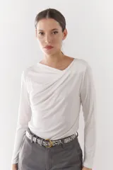Remera blanca de viscosa con cuello drapeado y mangas largas.