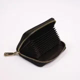 Billetera negra con textura tejida y cierre dorado con dije.