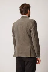 Blazer de corte slim fit confeccionado en pana de textura suave, con cierre frontal de dos botones, solapas clásicas y bolsillos laterales con solapa.