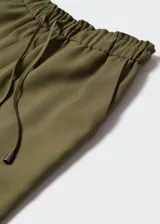 Pantalón fluido de corte recto y estilo jogger, confeccionado en tejido ligero. Presenta cintura elástica con cordón ajustable y dos bolsillos laterales.