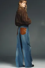 Jeans de tiro alto con corte wide leg y pernera recta. Presentan un diseño de cinco bolsillos con efecto lavado y cierre frontal mediante cremallera y botón metálico.