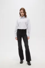 Pantalon jean de corte oxford, color negro, con tiro medio y ruedo deshilachado.