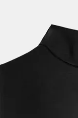 Camiseta sin mangas de corte ajustado con cuello subido, confeccionada en tejido liso de color marrón.