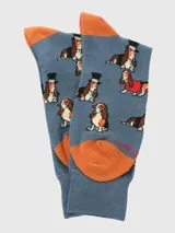 Calcetines de largo medio color gris azulado con estampado de perros Basset Hound con diferentes accesorios. Presenta talón y puntera en color naranja.