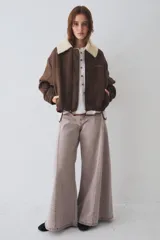 Campera bomber marrón de paño de lana, con cierre frontal, cuello de corderito sintético blanco desmontable, bolsillos laterales, puños y dobladillo elásticos, y logo bordado en el pecho.